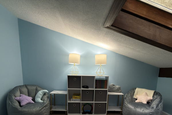 Cozy loft retreat with lounge seating, books, and board games. Perfect for unwinding after a day at the lake.