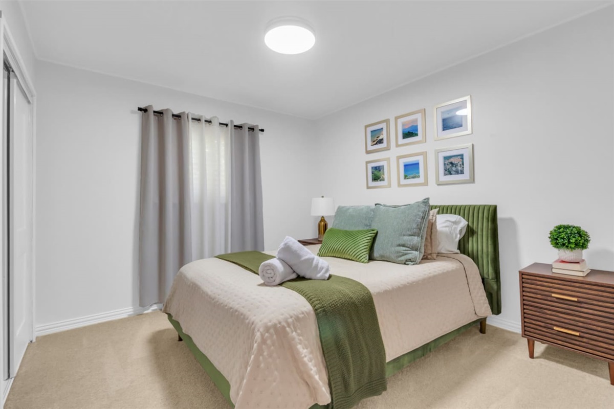 Guets bedroom with a queen bed and black out curtains