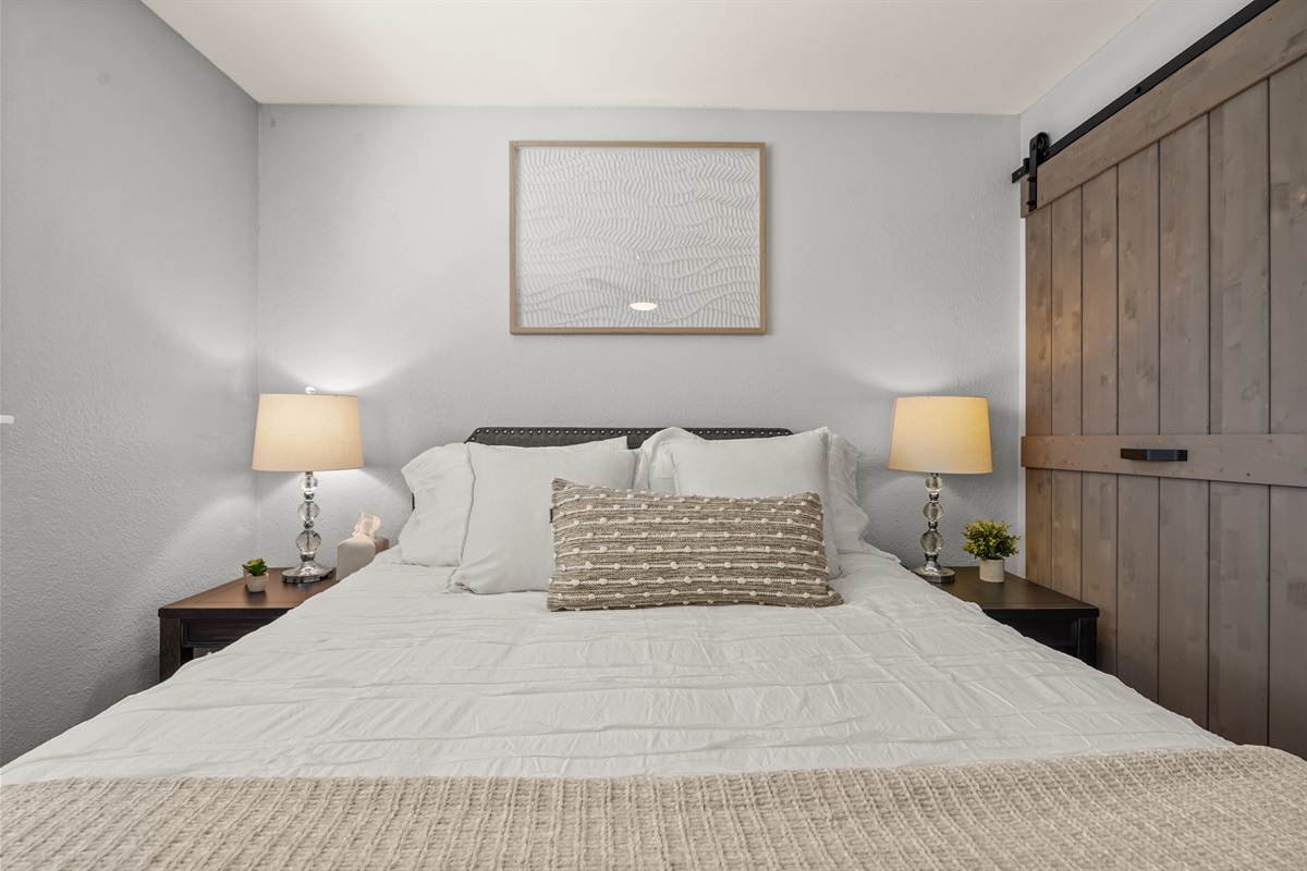 Bright upstairs bedroom featuring a queen bed and comfortable accommodations for guests.