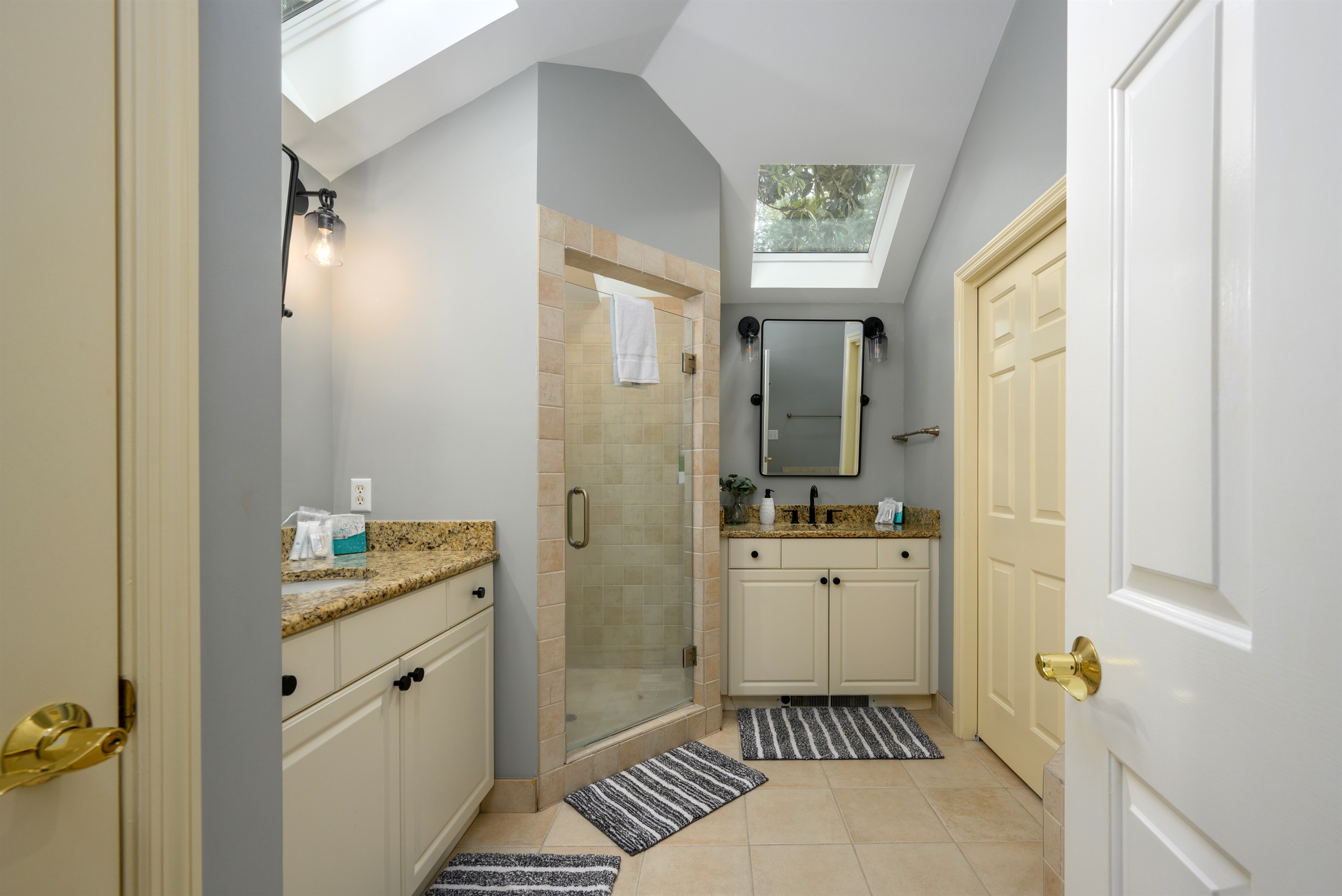 Primary King bathroom with dual sinks and standalone walk-in shower