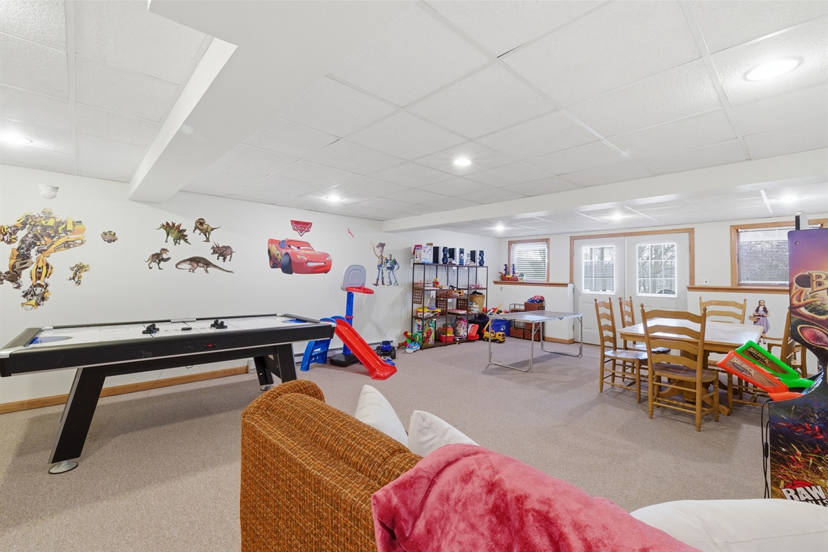 Playroom for kids and adults.  Air hockey, stereo system, toys, arcade, seating area.