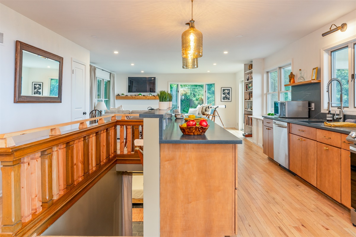 Experience the perfect blend of charm and functionality with this light-filled kitchen and open stairway design.