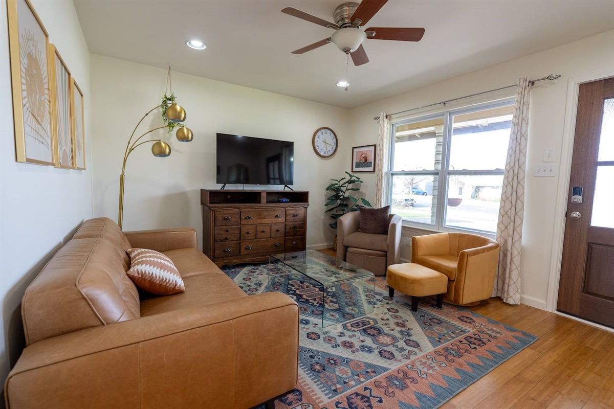 spacious living room with leather couch, TV, sitting area, reading corner