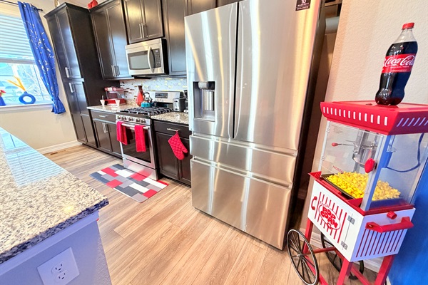 Fully equipped kitchen with a popcorn cart nearby—movie-night snacks made easy.
