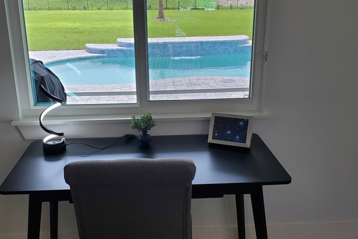 Office desk and chair and view of backyard