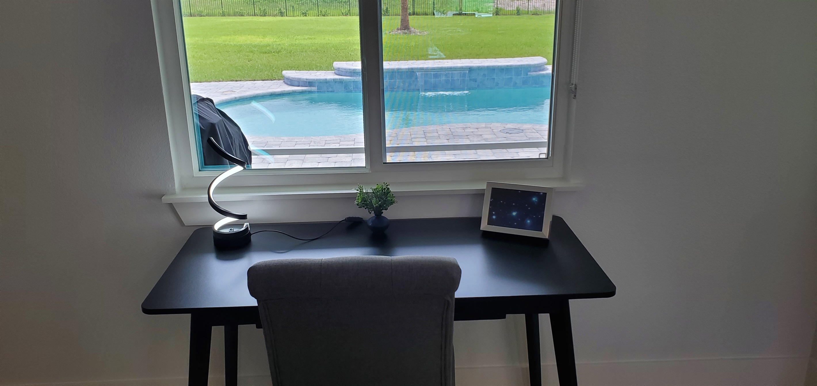 Office desk and chair and view of backyard