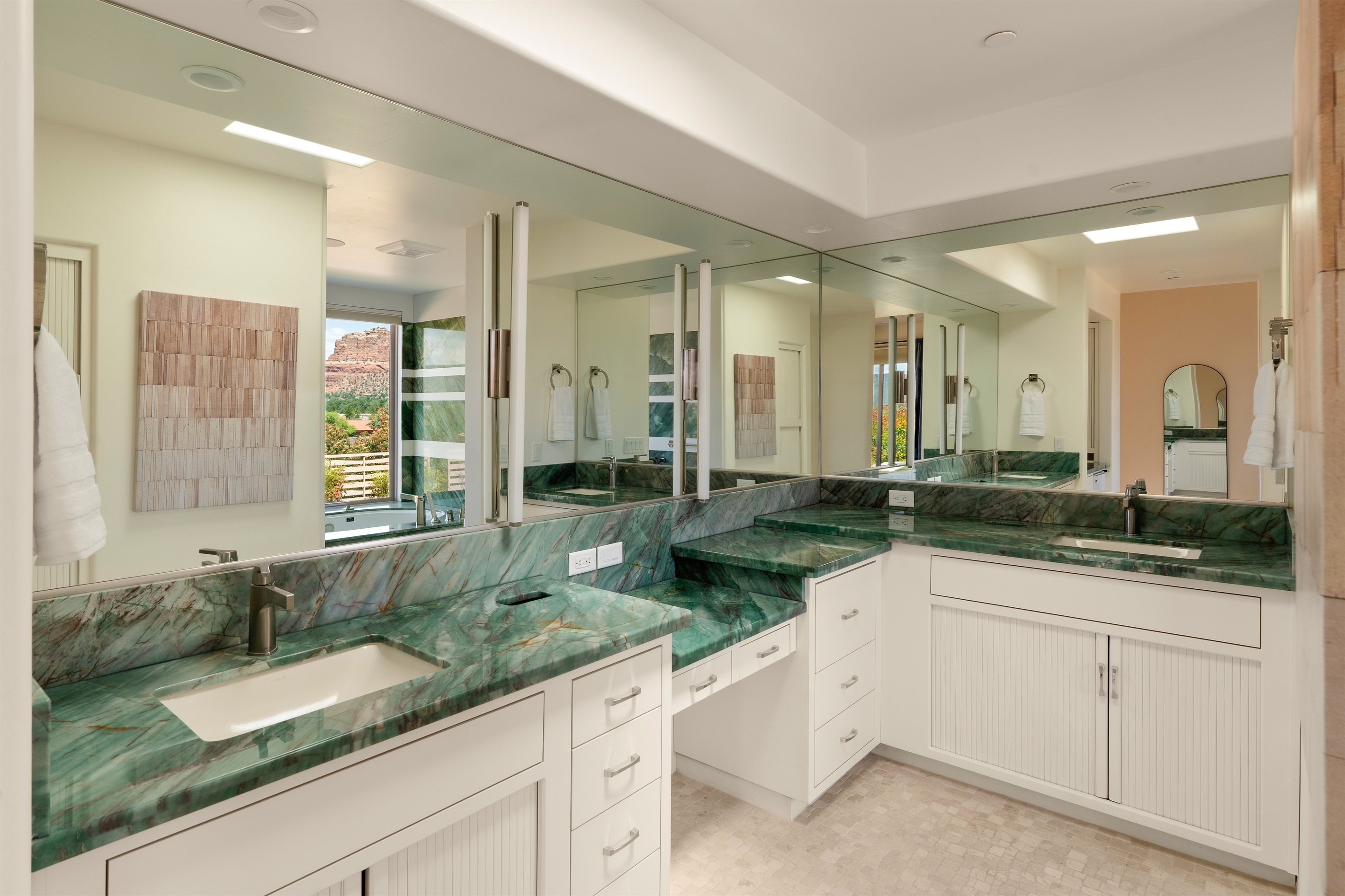 Get ready in style. The spa-like primary bathroom boasts expansive green marble countertops, dual vanities, and premium fixtures for an elevated stay.
