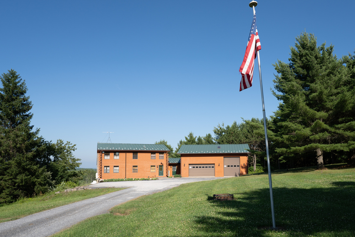 Long driveway with flagpole beside the lawn