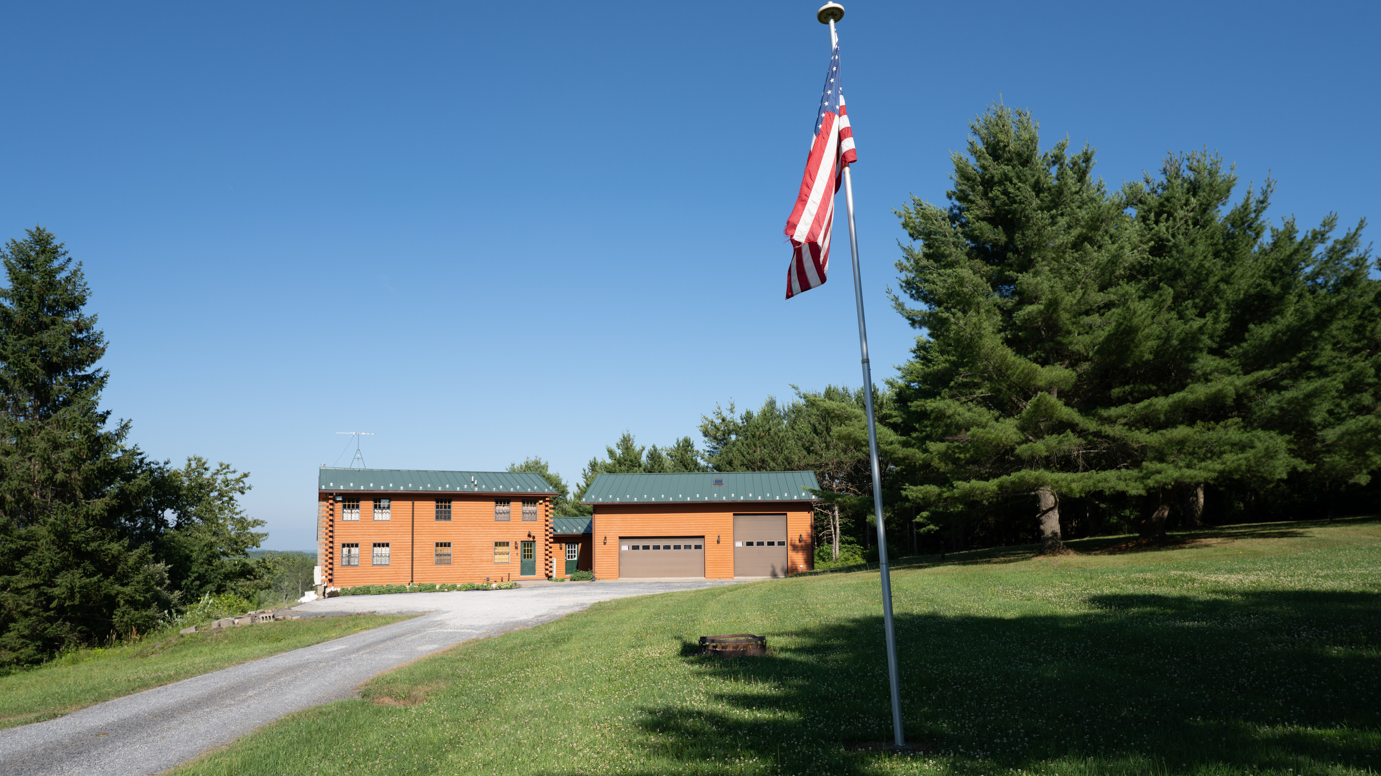 Long driveway with flagpole beside the lawn
