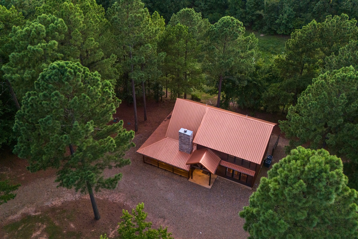 Surrounded by trees with a large circular drive for easy access.