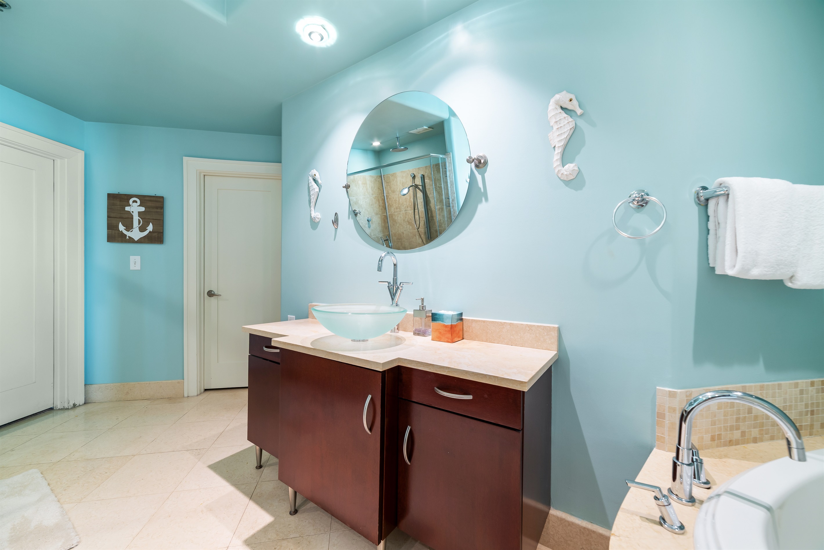 Elegant details define this bathroom. From the modern glass sink and sleek fixtures to the spacious walk-in shower, every element contributes to a luxurious experience.