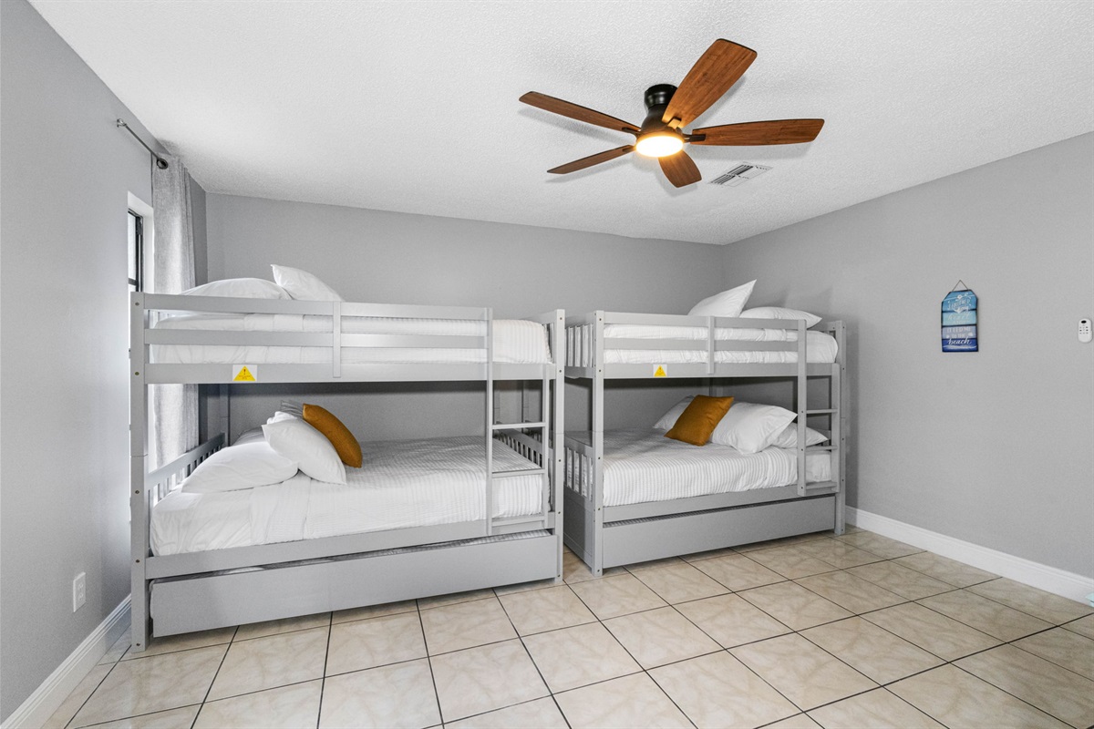 Featuring two sets of sleek modern gray bunk beds with full over full and twin trundles configurations.