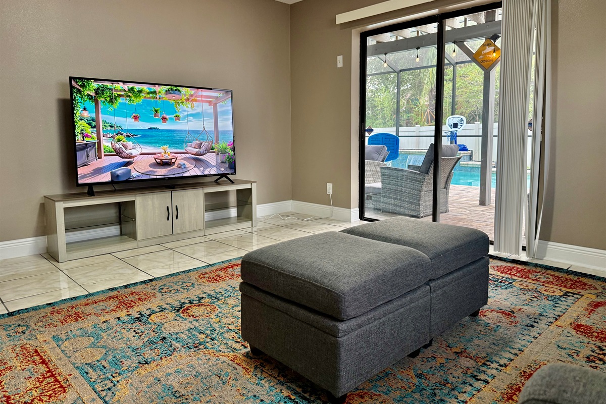The room is bright and airy, thanks to a wide glass sliding door that leads directly to a screened patio—making indoor-outdoor living seamless.