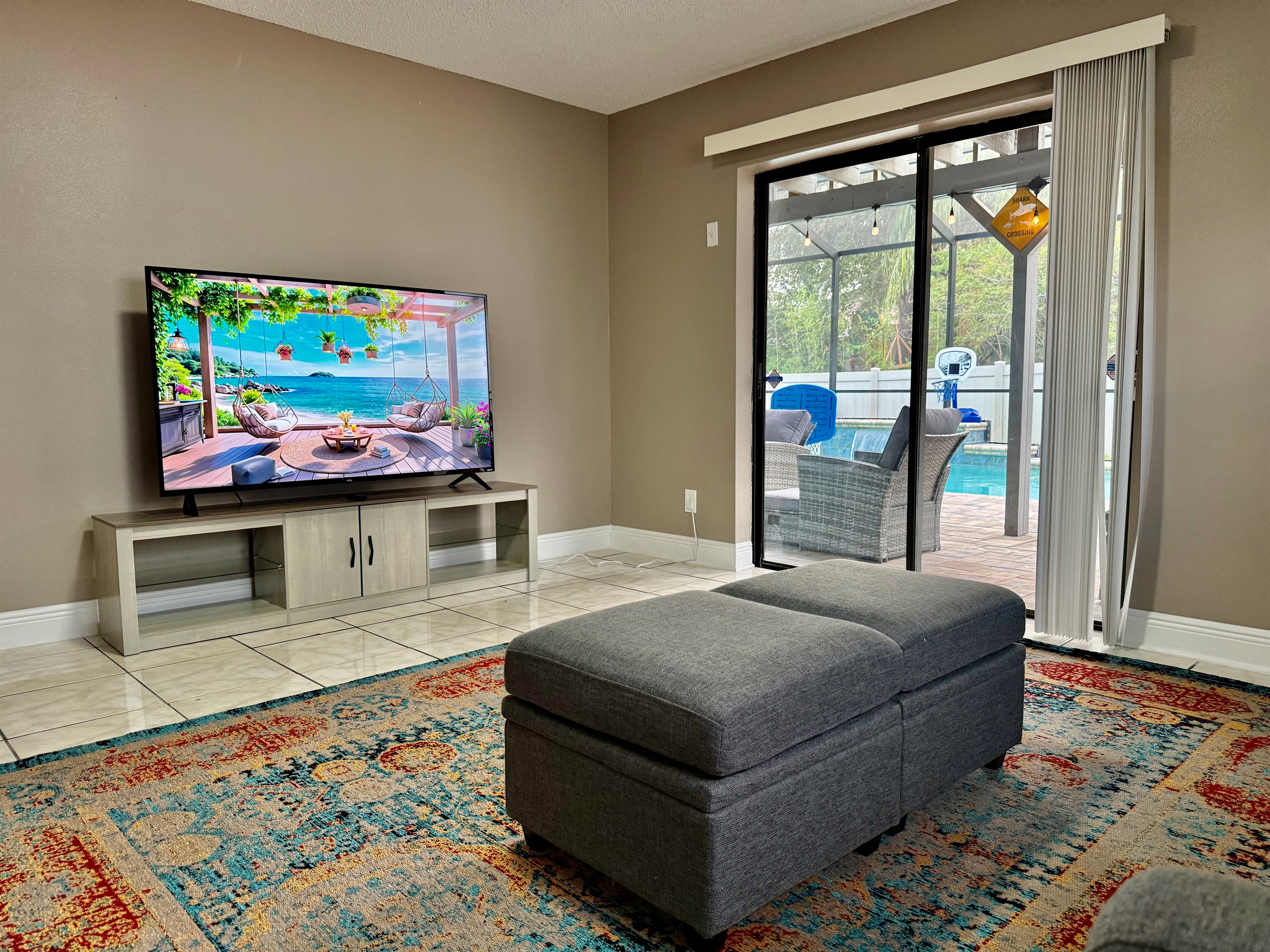 The room is bright and airy, thanks to a wide glass sliding door that leads directly to a screened patio—making indoor-outdoor living seamless.