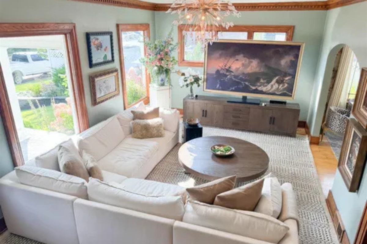 A spacious living room with soft natural light, a large TV, and room for everyone to settle in.