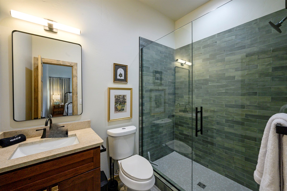 Spa-style bath with sleek glass shower and soft green tile 💧🖤