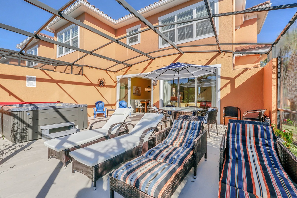 Private covered lanai with seating area, hot tub and lounge chairs