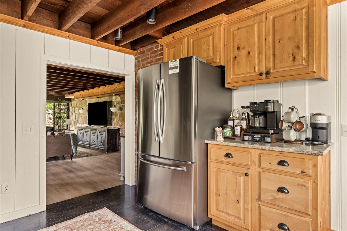Fully equipped kitchen with stainless appliances and a stocked coffee bar, just steps from the living space.