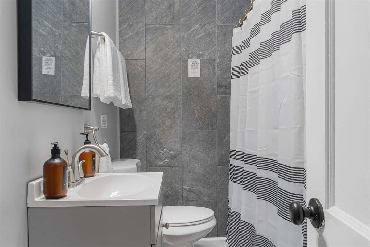 Compact and modern full bathroom with a clean walk-in shower, fresh towels, and complimentary toiletries