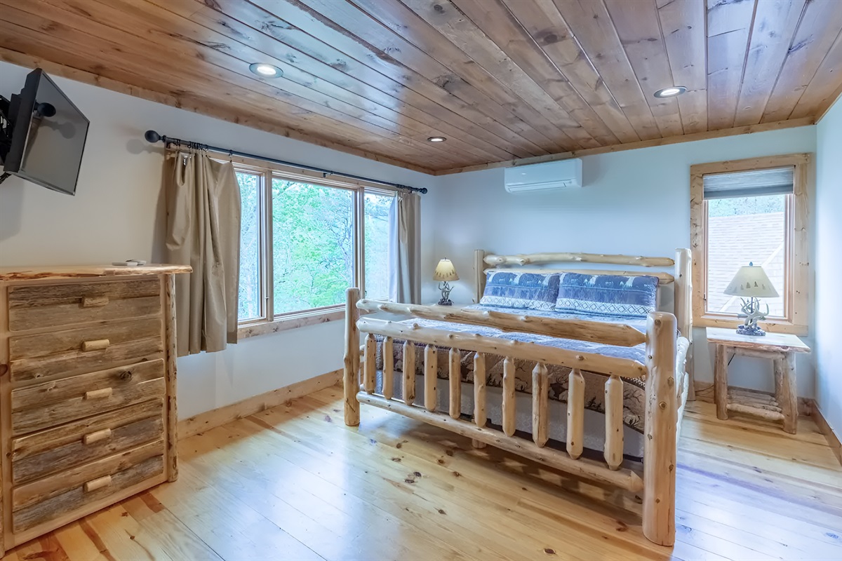The upper level king bedroom features a cozy setup and a TV.