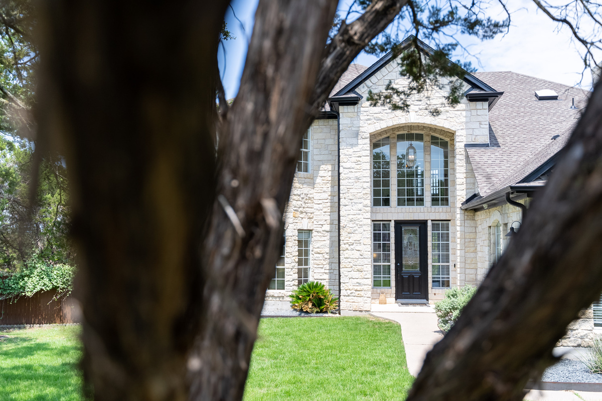 A stately arched entrance welcomes guests to this Hill Country home.