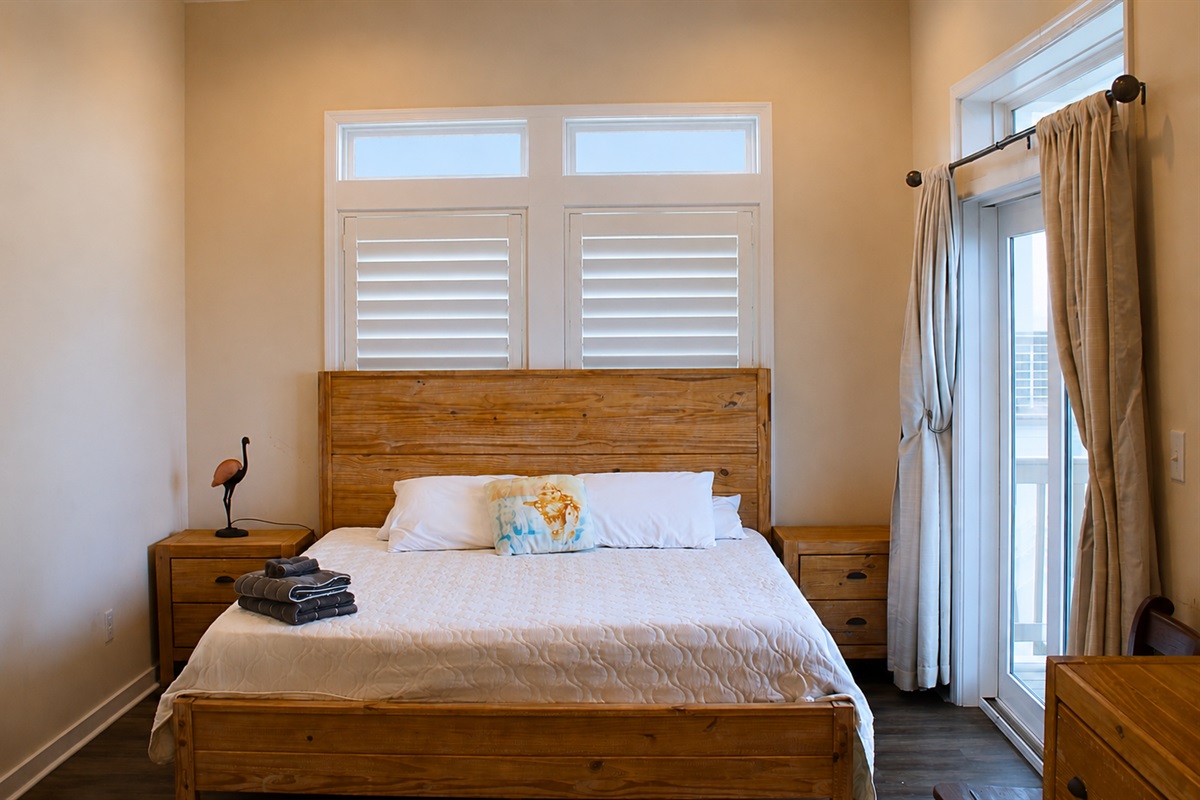 Master Bedroom: Sun-drenched retreat with beach views and modern wooden accents! Relax and unwind.