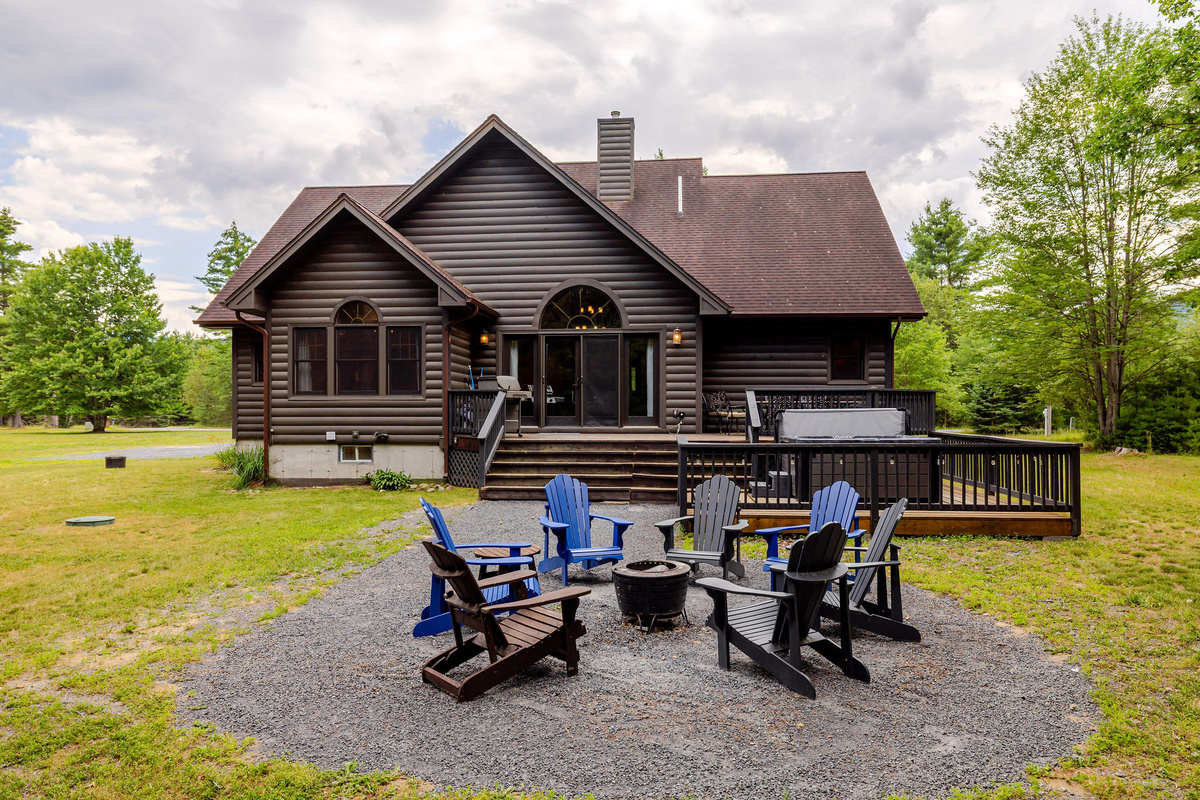 Gather around the fire pit, soak in the private hot tub, or relax on the spacious deck while surrounded by the peaceful beauty of the Adirondack forest.
