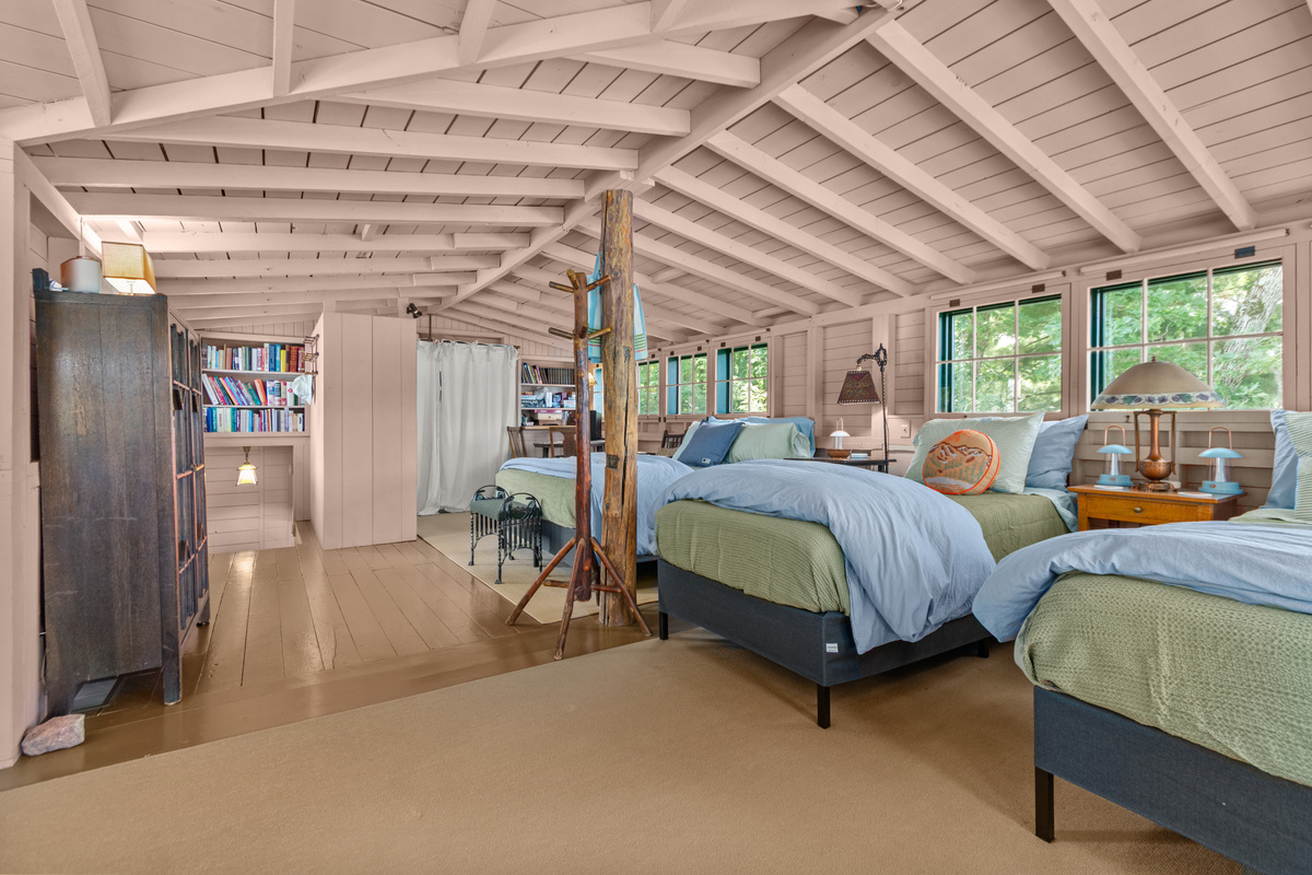 Head upstairs and settle into the cozy sleeping space, where multiple beds and charming cottage details bring back the fun, nostalgic feeling of summer camp by the lake.