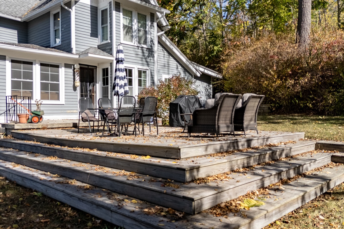Sprawling patio with cozy seating for evening cocktails and family BBQs — lake views included