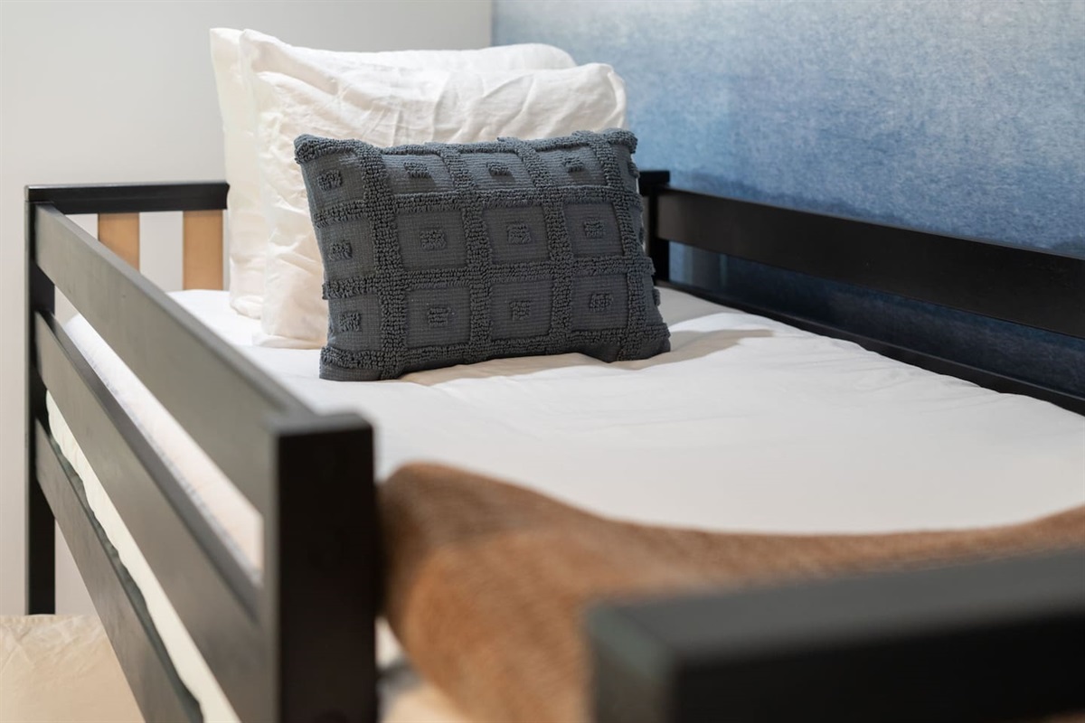 Close-up of the lower bunk showcasing plush pillows and cozy bedding.