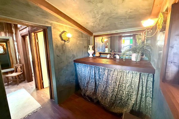 Just inside the courtyard entrance, the design gives guests direct access to both powder rooms without crossing the house. Hand-troweled plaster walls add old-world texture, while the washer and dryer hide neatly behind that tailored curtain.