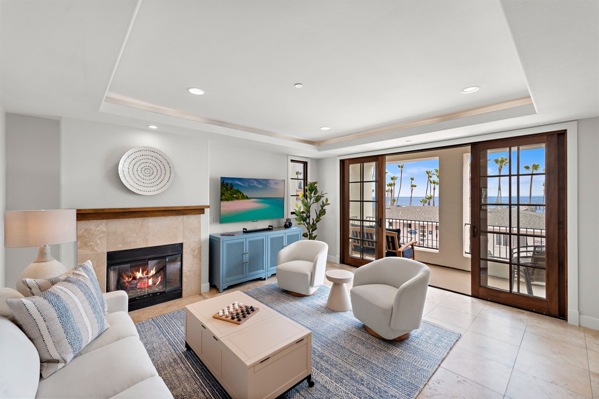 The living room has lots of comfortable seating, views and natural light pouring in from the balcony.