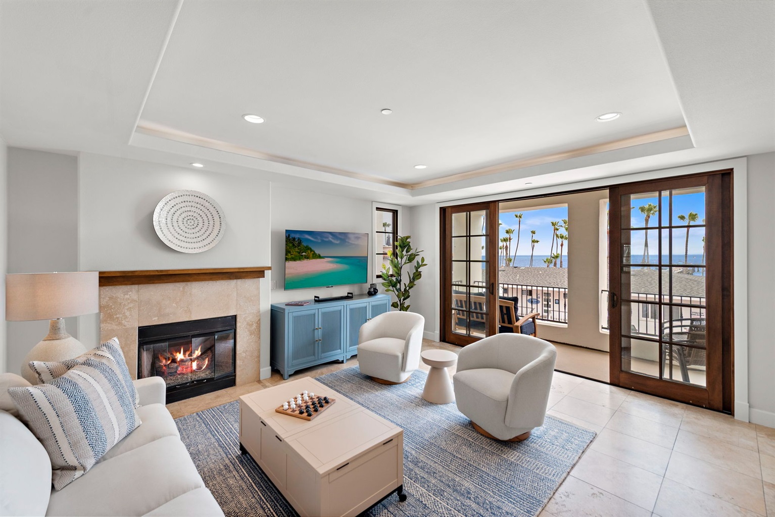 The living room has lots of comfortable seating, views and natural light pouring in from the balcony.