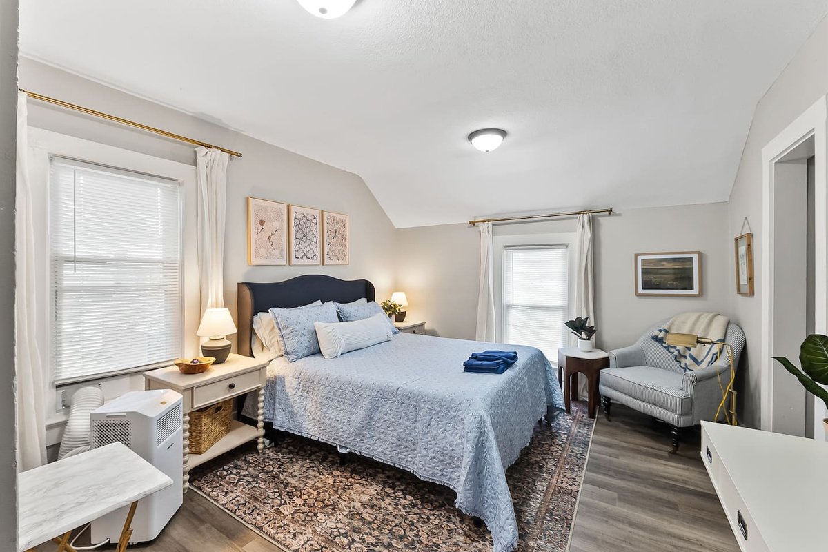 A bright, restful bedroom with a comfortable sitting nook for unwinding at the end of the day.
