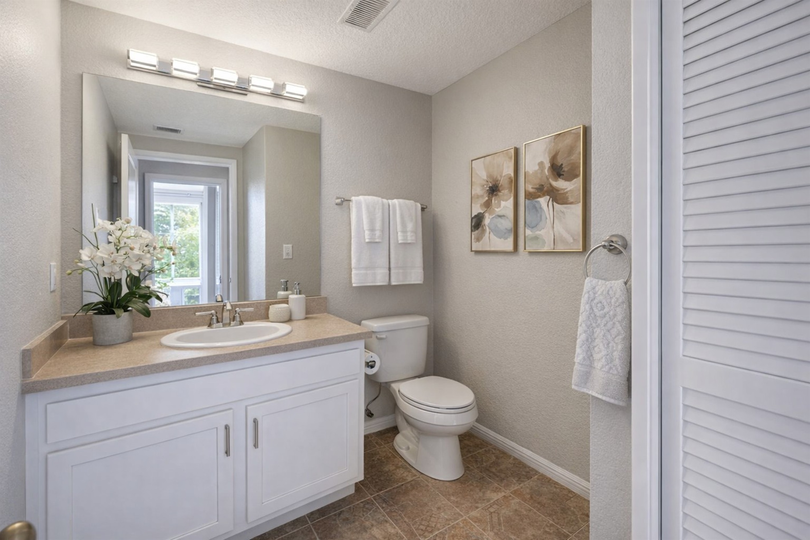 Modern bathroom with a single sink vanity and neutral decor.