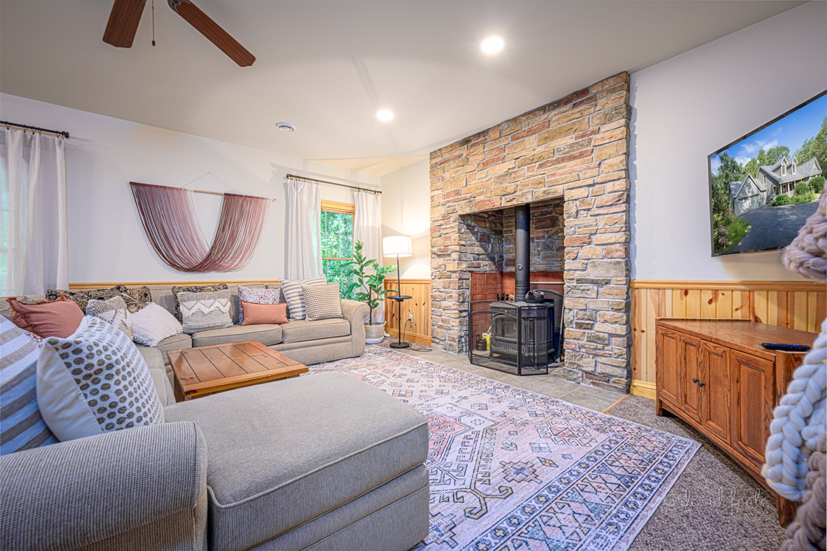 Basement living room with wood burning stove and Roku TV