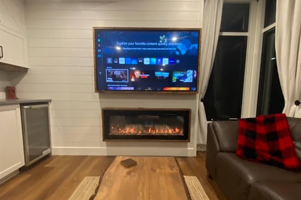 Downstairs entertainment area features a fireplace as well as large-screen TV