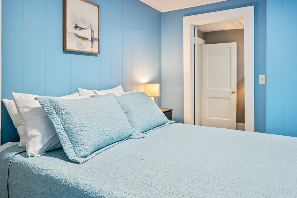 This bedside vantage point highlights the architectural flow between the second-floor queen bedroom and adjacent Pebble Nook. Close the door for complete evening privacy, or keep it wide open to enjoy the seamless, bright flow of the home.