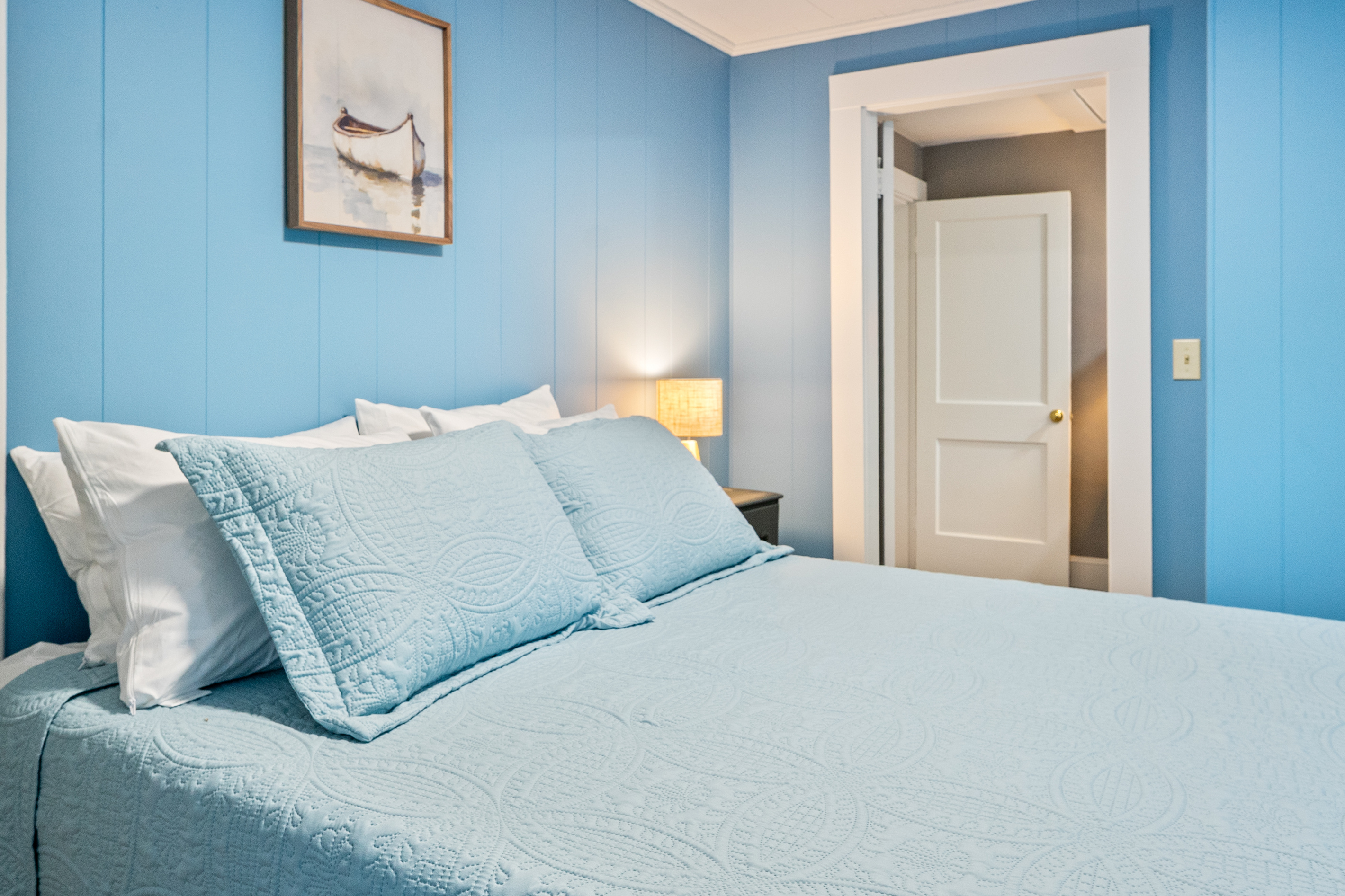 This bedside vantage point highlights the architectural flow between the second-floor queen bedroom and adjacent Pebble Nook. Close the door for complete evening privacy, or keep it wide open to enjoy the seamless, bright flow of the home.