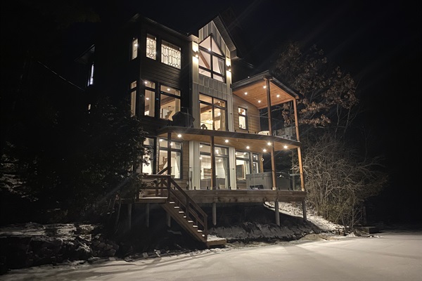 Cottage seen from edge of lake and beach area