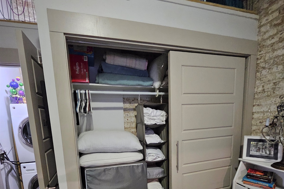 Wall closet contains extra bedding, linens and portable/folding twin cots.