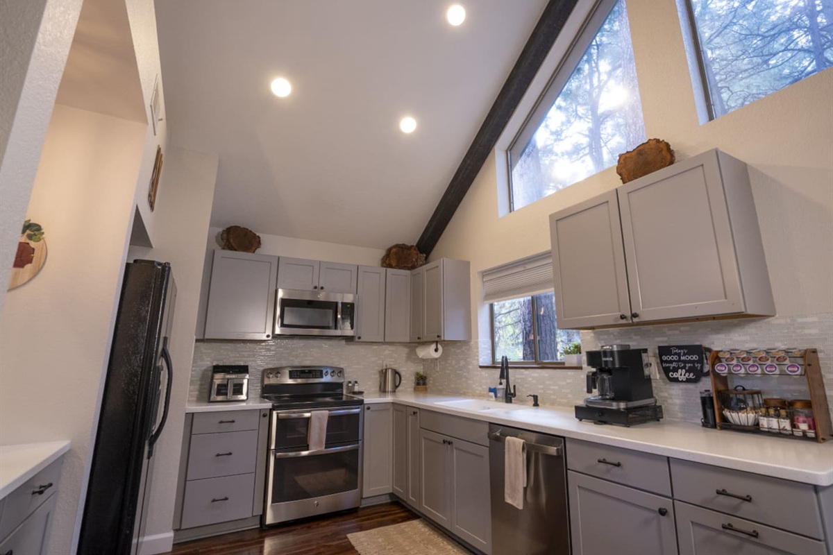 Bright kitchen with high ceilings, full-size appliances, and space for simple meals during your stay.