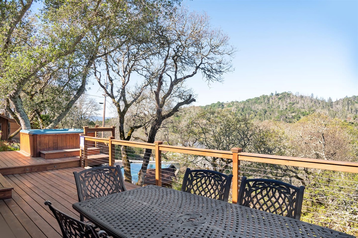 The large deck just off the family and living rooms has expansive views of the Mayacama Mountains. On this deck is the hot tub and outdoor dining table.