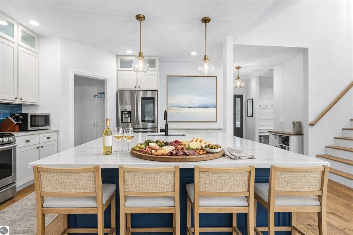 A spacious chef’s kitchen with an oversized island, comfortable seating, and plenty of room for charcuterie boards, wine, and good conversation after a day exploring Northern Michigan.