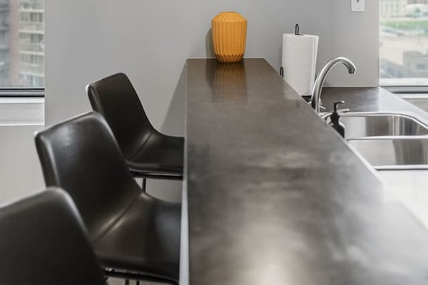 This modern kitchen offers a spacious bar, floating shelf décor, and plenty of counter space. Whether you’re preparing dinner or grabbing takeout, enjoy the perfect blend of style, convenience, and functionality downtown.