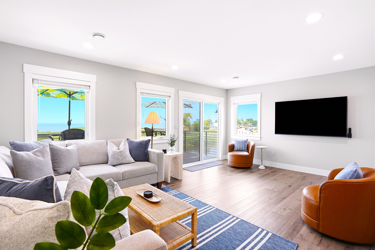 Large windows fill the room with natural light while offering beautiful views, creating a relaxing space to watch your favorite shows or simply enjoy the peaceful waterfront setting.