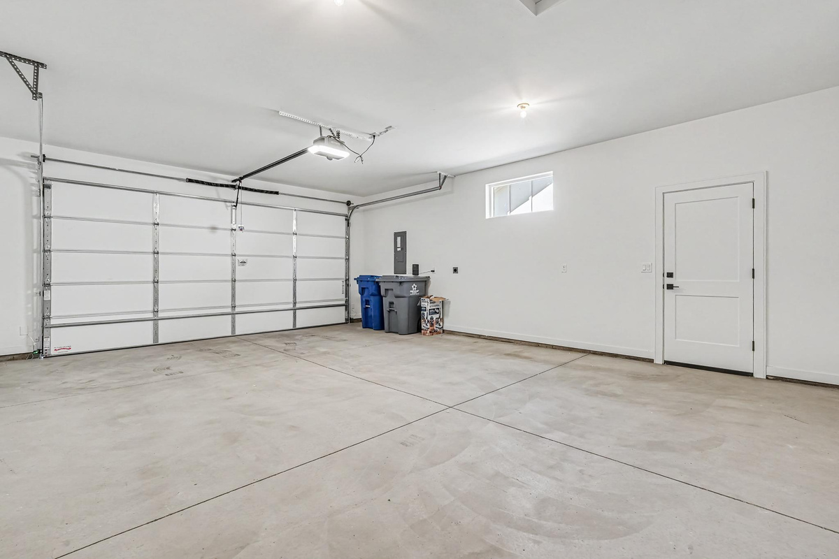 Spacious two-car garage with convenient access to the backyard through a dedicated side door.