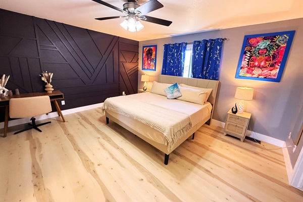 A stylish retreat with bold design and cozy charm. The dark accent wall and vibrant art create a perfect balance of warmth and modern elegance. A space to relax and feel inspired.