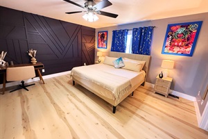 A stylish retreat with bold design and cozy charm. The dark accent wall and vibrant art create a perfect balance of warmth and modern elegance. A space to relax and feel inspired.