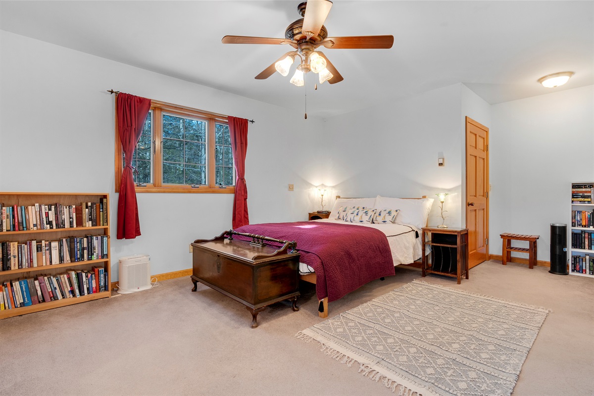 Primary bedroom with a queen bed. The bedroom is a loft style and overlooks the main living area. 